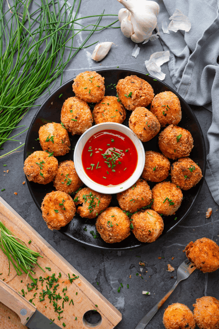 Golden, crispy loaded baked potato tots topped with melted cheese, bacon bits, and chopped green onions