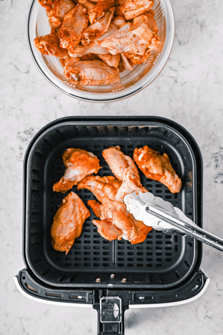 Crispy golden chicken wings cooking in air fryer, oven, or skillet