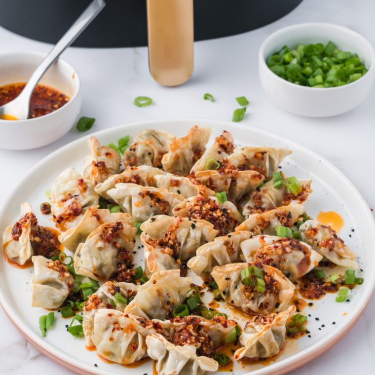 Golden crispy air fryer Trader Joe&rsquo;s potstickers served on a plate with soy dipping sauce