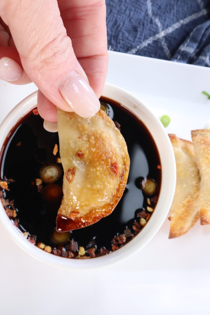 Adding fried potstickers to sauce