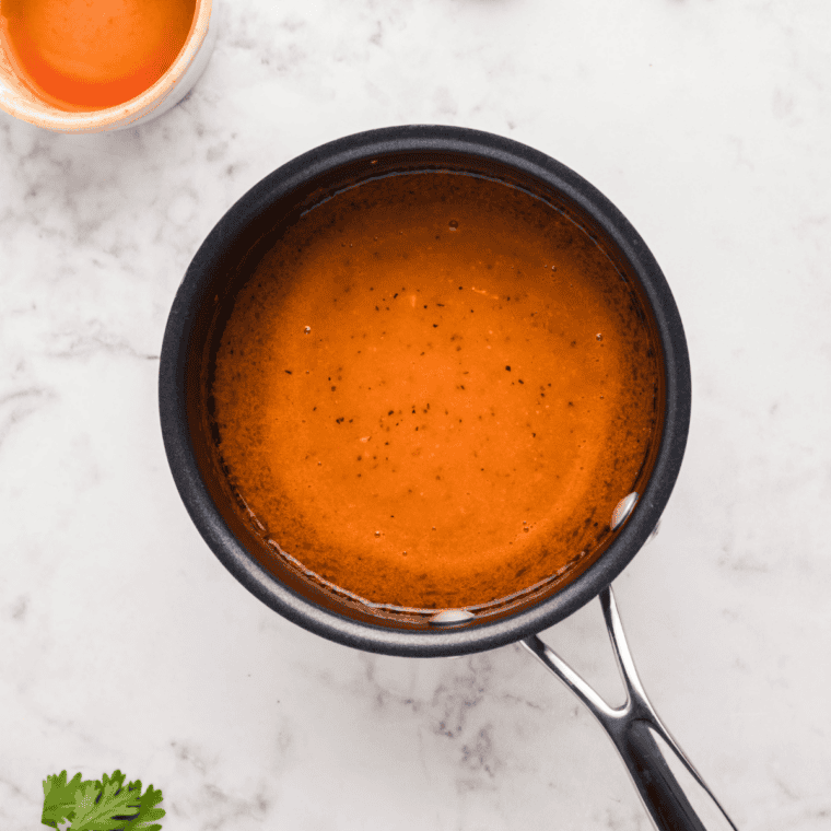 Simmering butter, hot sauce, vinegar, and Worcestershire sauce to make buffalo wing sauce.