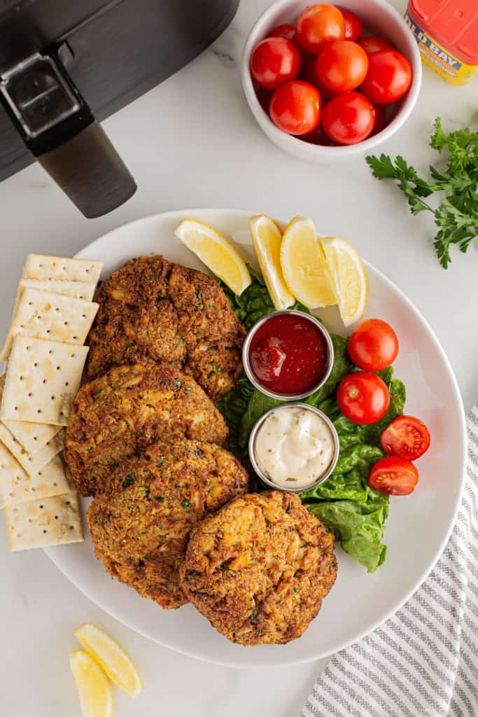 Plate of crispy crab cakes topped with a drizzle of creamy Keto Remoulade Sauce.