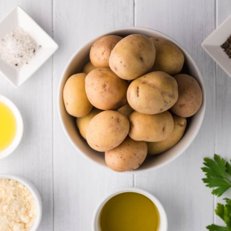 Ingredients needed for Crispy Air Fryer Greek Potatoes on wooden table.