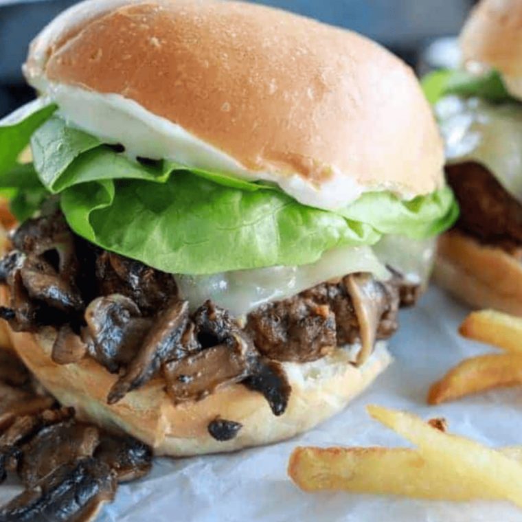 Blackstone griddle frozen hamburgers flipping with melted cheese on top