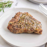 Frozen lamb chops in the air fryer, cooked golden-brown and garnished with fresh rosemary
