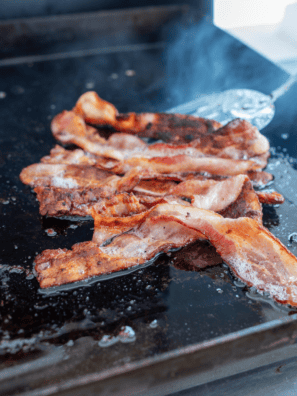 Cooking crispy bacon on the Blackstone griddle for a perfect texture.
