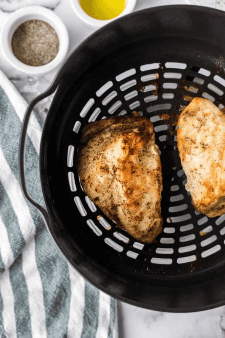 Placing chicken in Ninja Foodi air fryer and cooking.