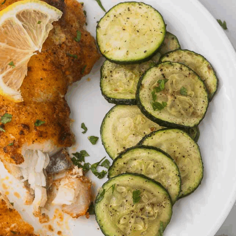 Crispy air-fried zucchini slices seasoned with zaatar on a white plate.