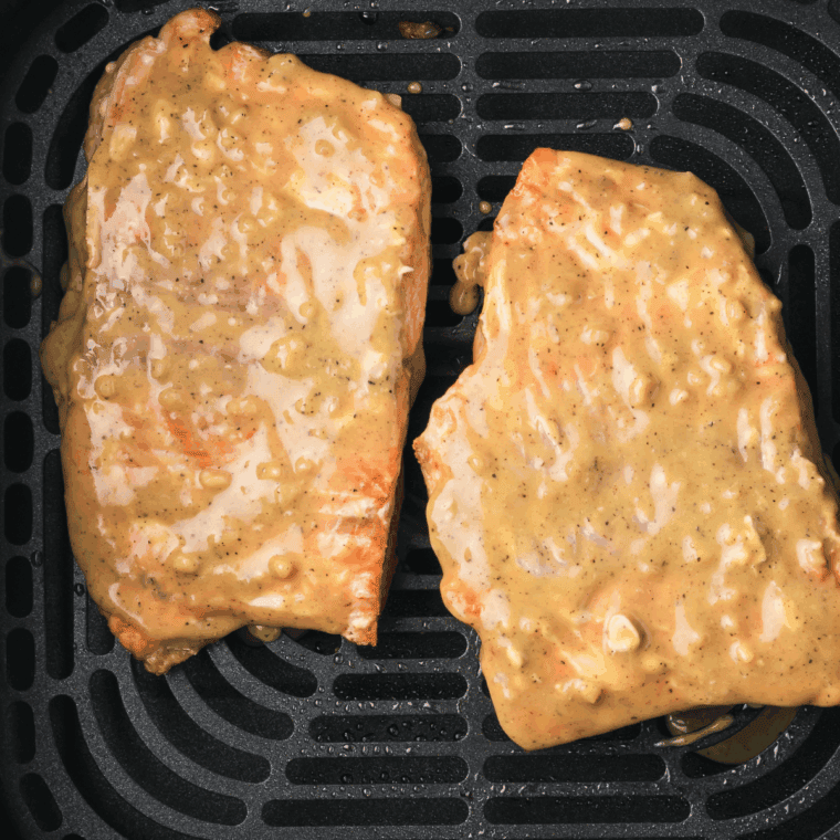 Marinating salmon fillets in miso glaze inside dish.