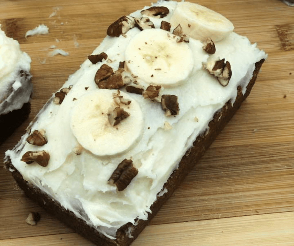 Air Fryer Banana Cake With Cream Cheese Frosting on cutting board