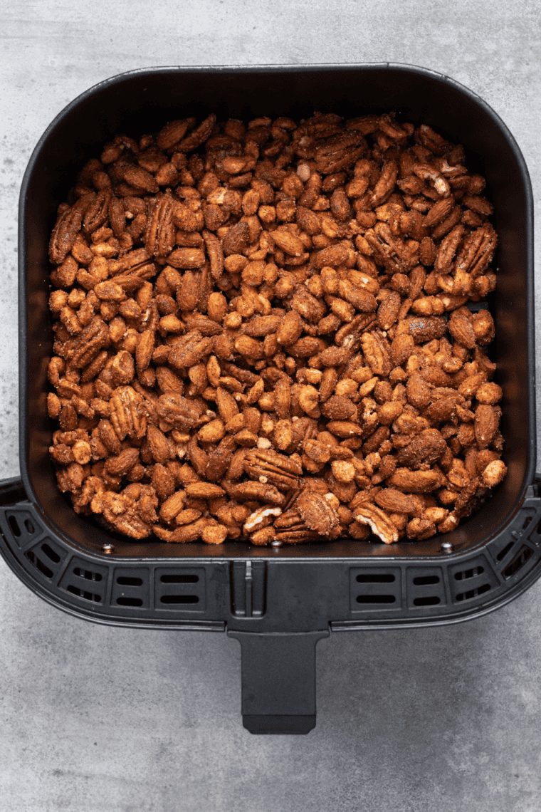 Air Fryer Barbecue Roasted Mixed Nuts with spices in the air fryer basket.