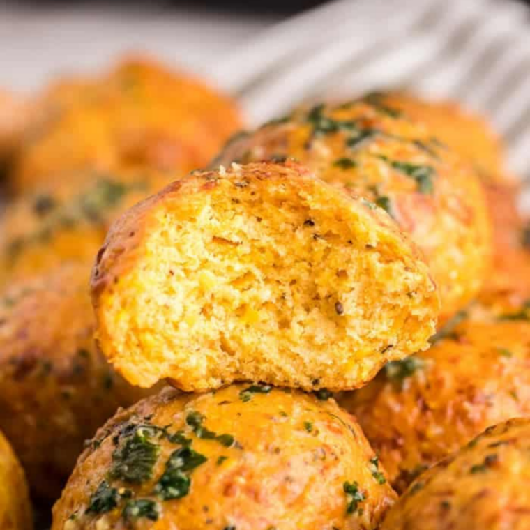 Close-up of freshly cooked air fryer cheese puffs with melted cheddar visible inside