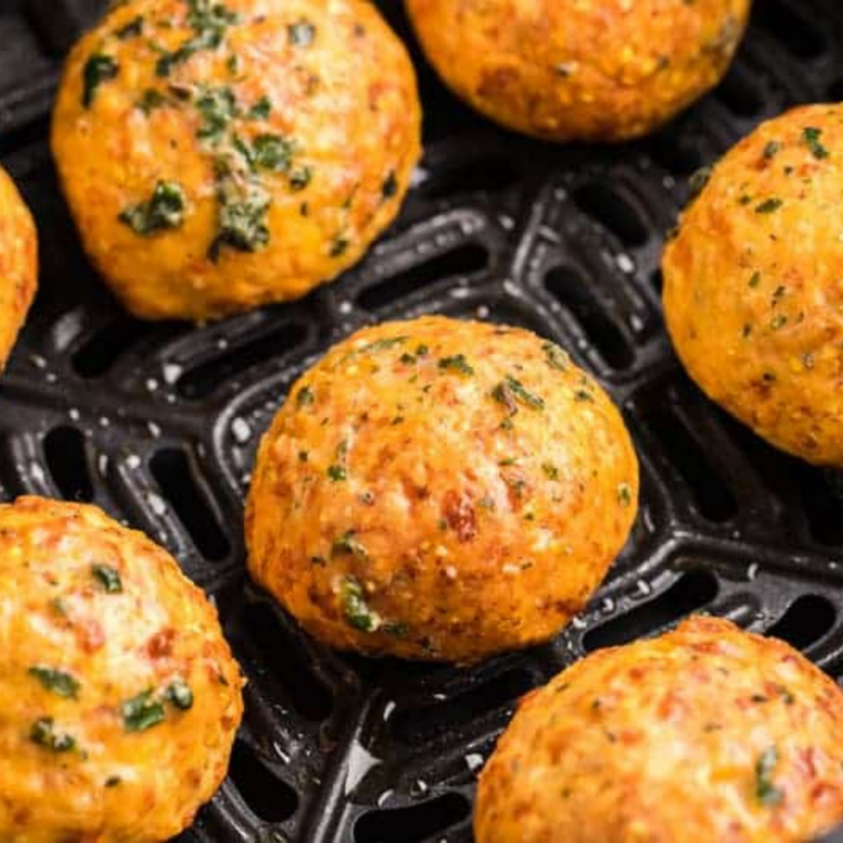 Crispy homemade cheese puffs served warm from the air fryer in a simple white bowl
