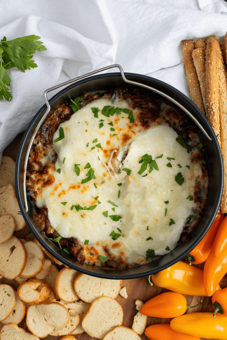 Air Fryer Cheesy Bacon Spinach Dip with melted cheese, crispy bacon, and fresh spinach in a golden, creamy dip