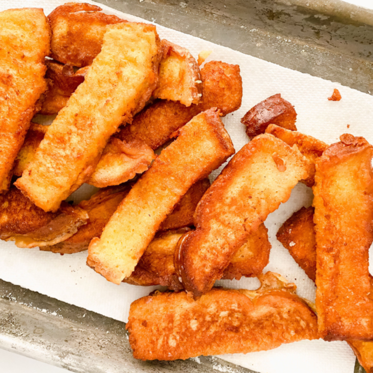 Crispy air fryer French toast sticks with a golden-brown exterior, served with syrup.