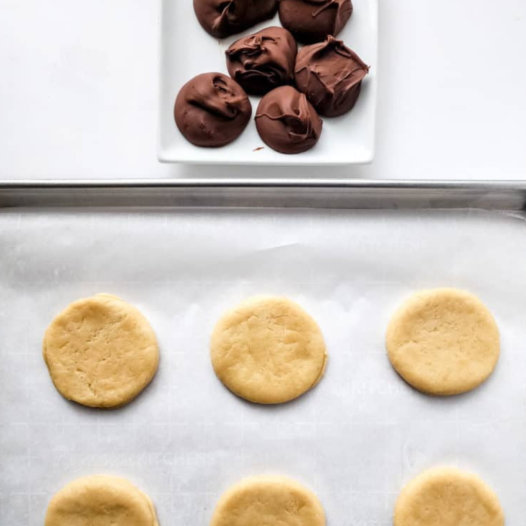 Flatten biscuits with a rolling pin, adding 1-2 tablespoons of Nutella in the center of each for the perfect Nutella Bomb.