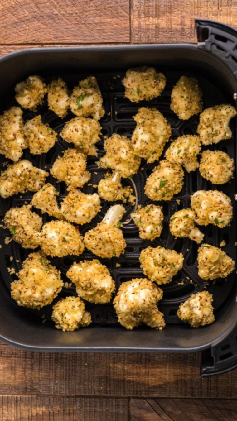 Cauliflower florets arranged in a single layer in the air fryer basket, ready for cooking.