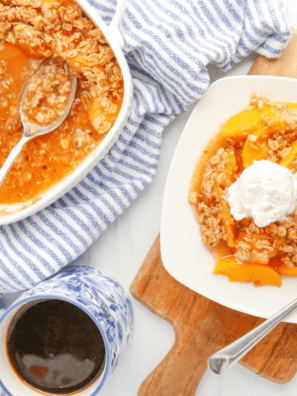 Golden brown Air Fryer Peach Crumble served warm in a white dish with a scoop of vanilla ice cream on top.