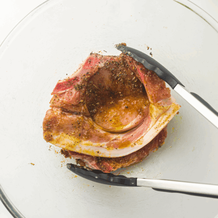 Brushing pork chops with olive oil and seasoning with ranch mix, garlic powder, salt, and black pepper for flavor.