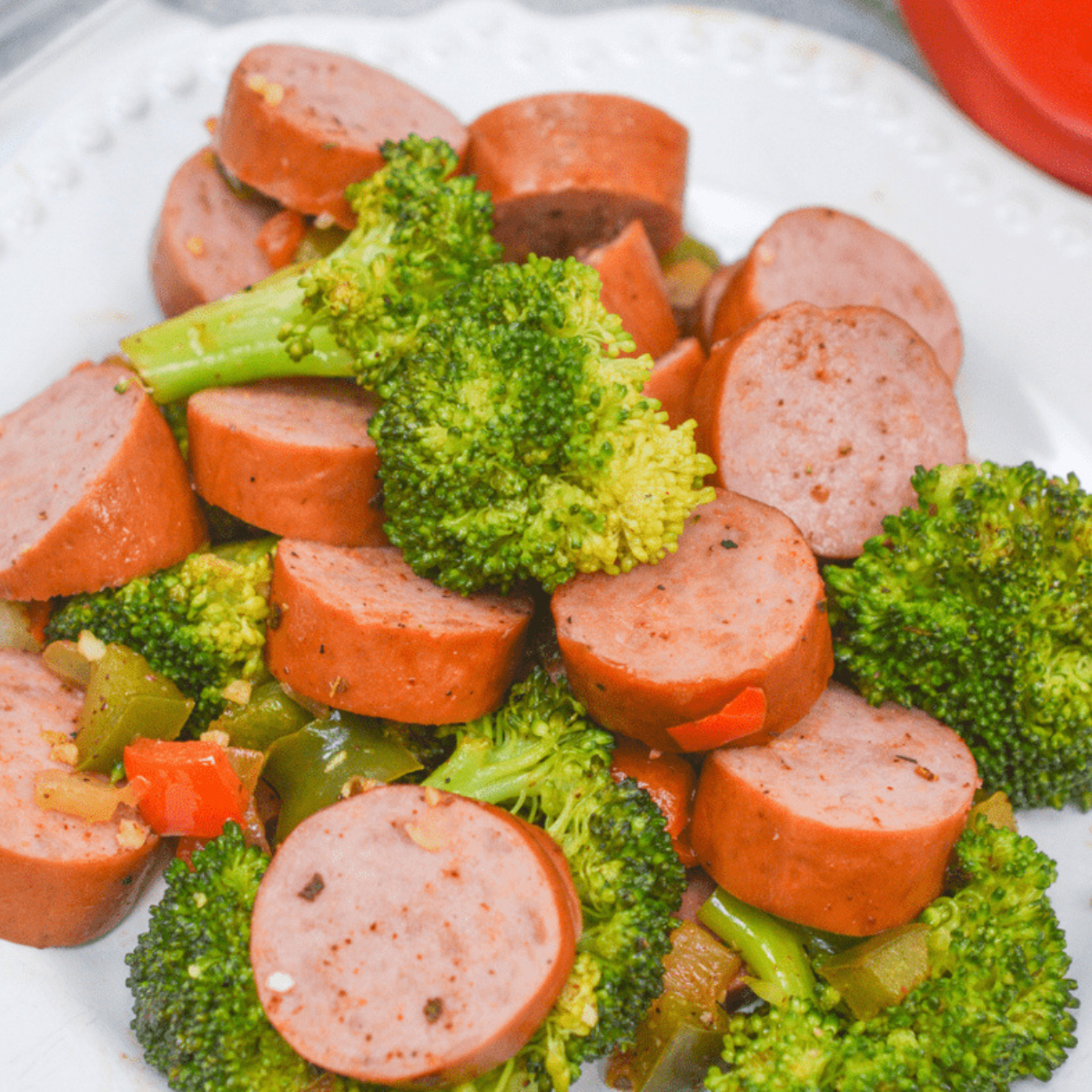 Crispy sausage and roasted broccoli in an air fryer basket, perfectly cooked and ready to serve.