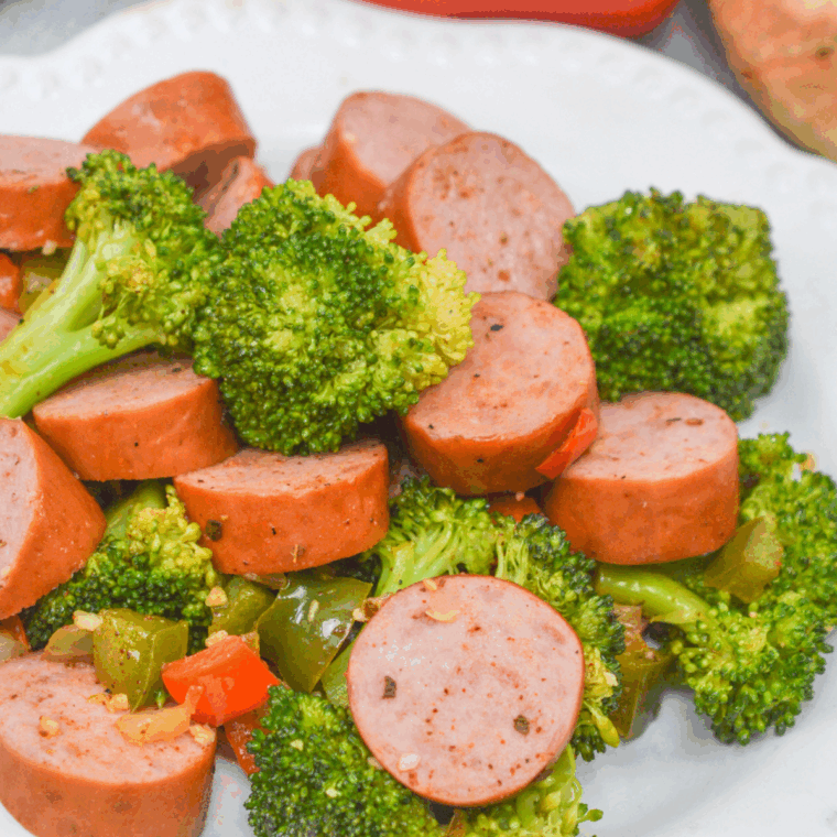 Plate of cooked sausage and broccoli.