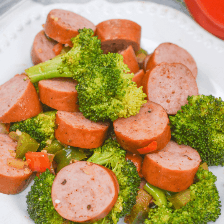 Air-fried sausage slices and roasted broccoli florets served on a plate, golden and perfectly cooked.