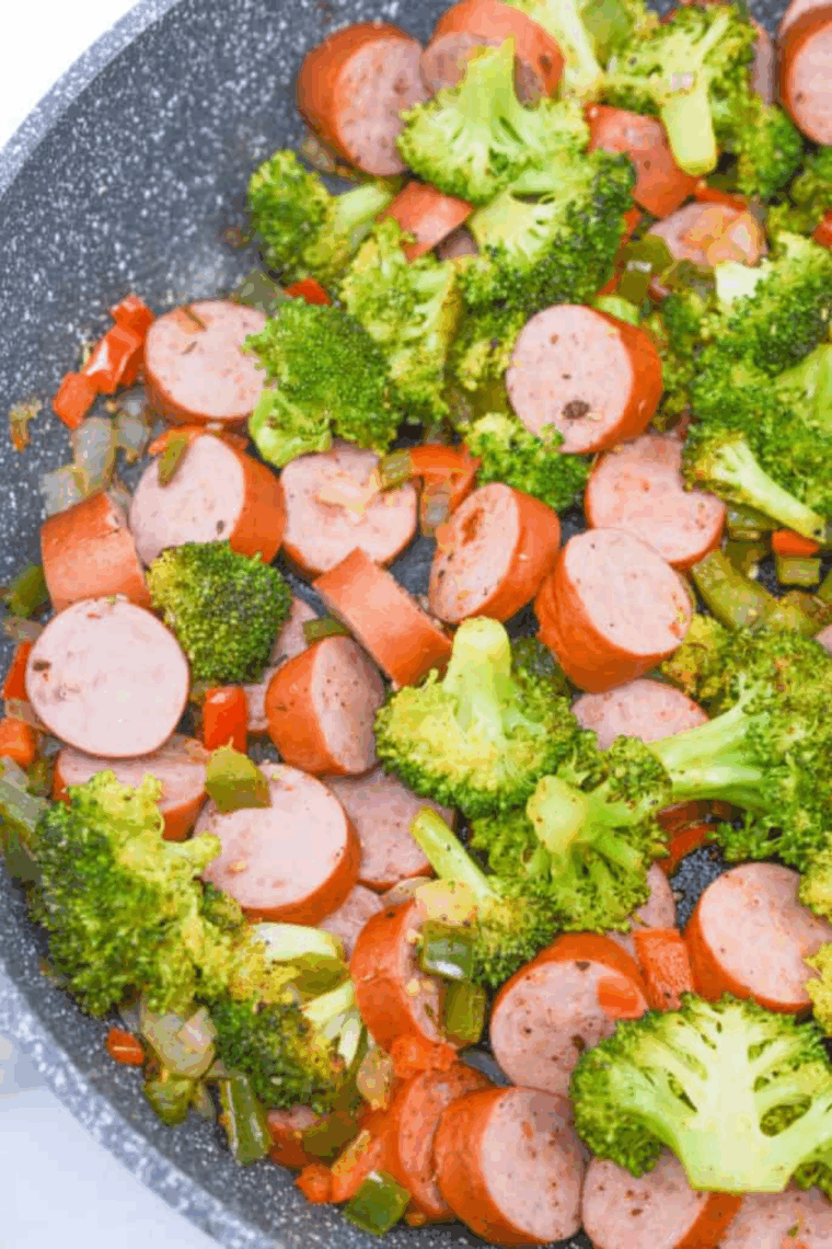 Seasoned sausage and vegetable mixture spread in a single layer inside an air fryer basket, ready to cook at 370°F.