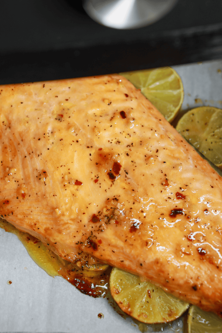 Cedar plank salmon fillets cooked in air fryer, glazed with maple bourbon, topped with cherry gastrique, parsley, and orange zest, served on a wooden plank.