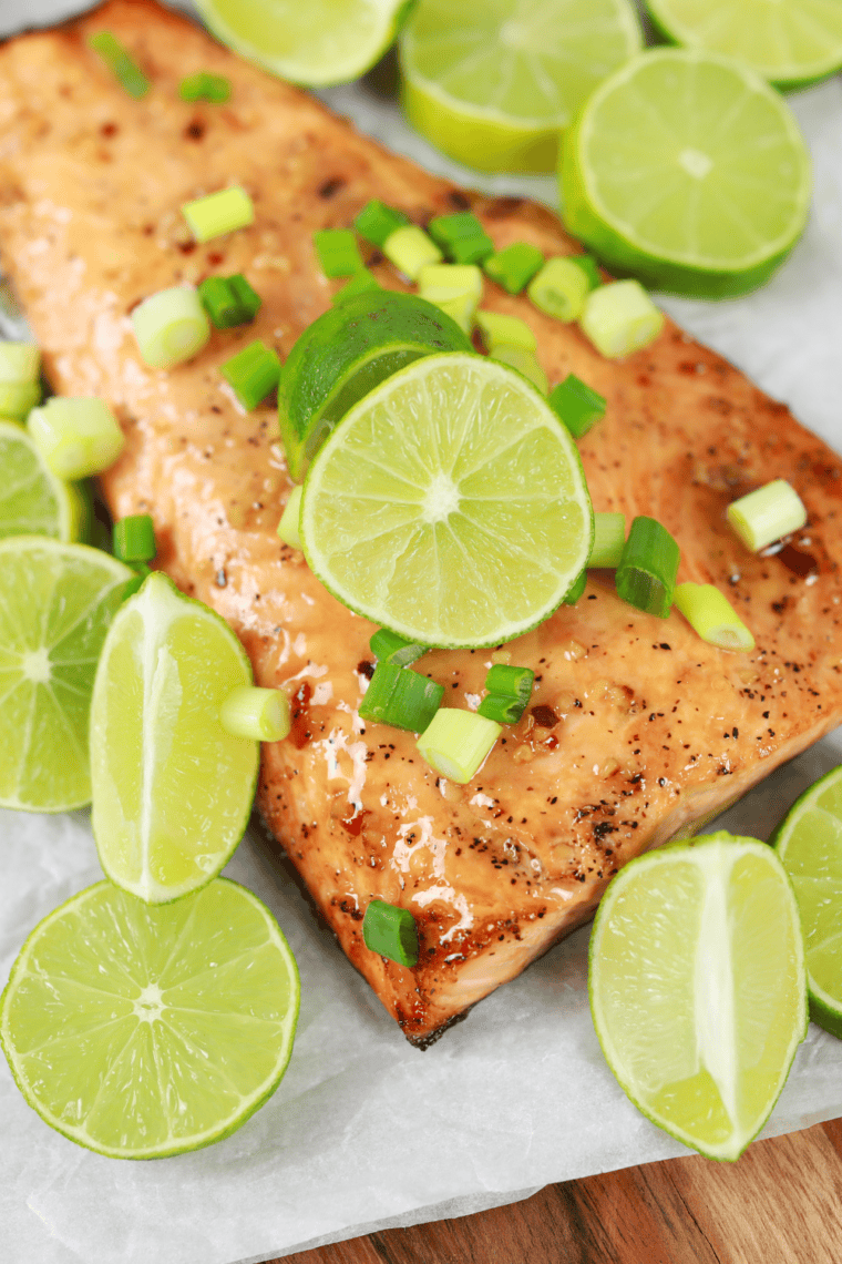 Air fryer Cedar Plank Salmon from Bonefish Grill topped with maple bourbon glaze, cherry gastrique, parsley, and orange zest on a soaked cedar plank, ready to serve.