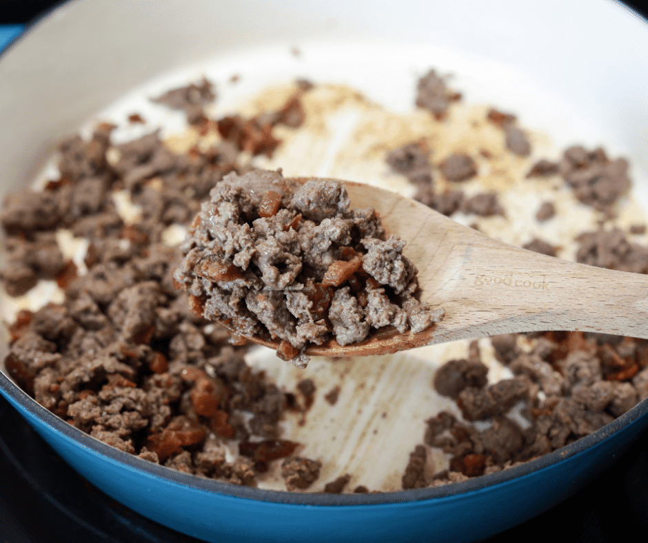 closeup: ground beef and bacon on a wooden spoon for cheeseburger bacon bombs