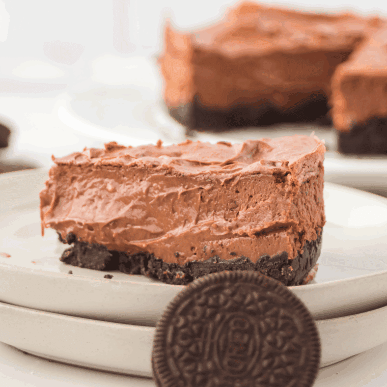 Slice of Copycat Cheesecake Factory Godiva Chocolate Cheesecake with layered chocolate and glossy ganache.
