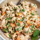 Close-up of creamy Southwest chicken salad showing corn and sun-dried tomato pieces.