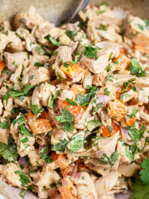 Close-up of creamy Southwest chicken salad showing corn and sun-dried tomato pieces.