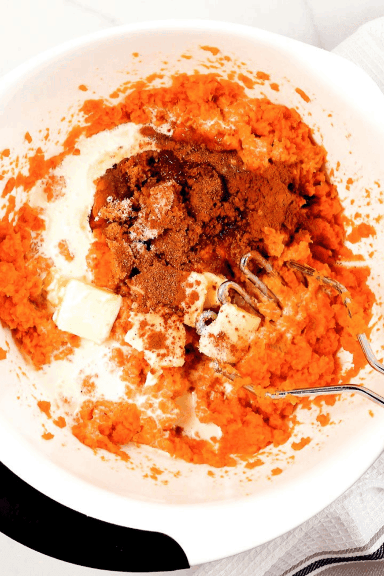 Mixing the sweet potatoes and filling ingredients in a large mixing bowl.