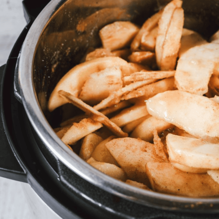 Place the sliced apples in your pressure cooker. Add in the sugar, which will help draw out the natural juices of the apples. Sprinkle in cinnamon, nutmeg, and cloves to your liking, along with a pinch of salt to enhance the flavors. If you’re using lemon juice, add it now to brighten the flavor and help preserve the apple butter.