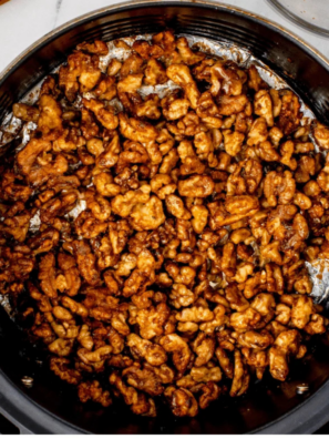 Bowl of honey roasted walnuts crisping in an air fryer basket