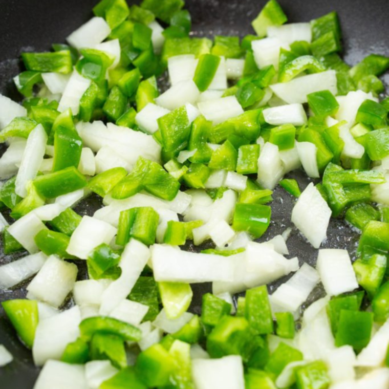 Sautéing onions and peppers in a skillet for Air Fryer Philly Cheesesteak Dip.