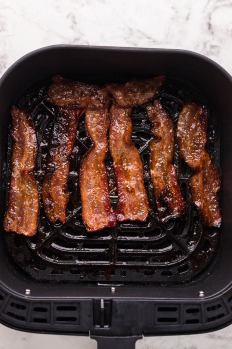 Air fryer with the timer set, cooking diced bacon pieces for homemade bacon bits.