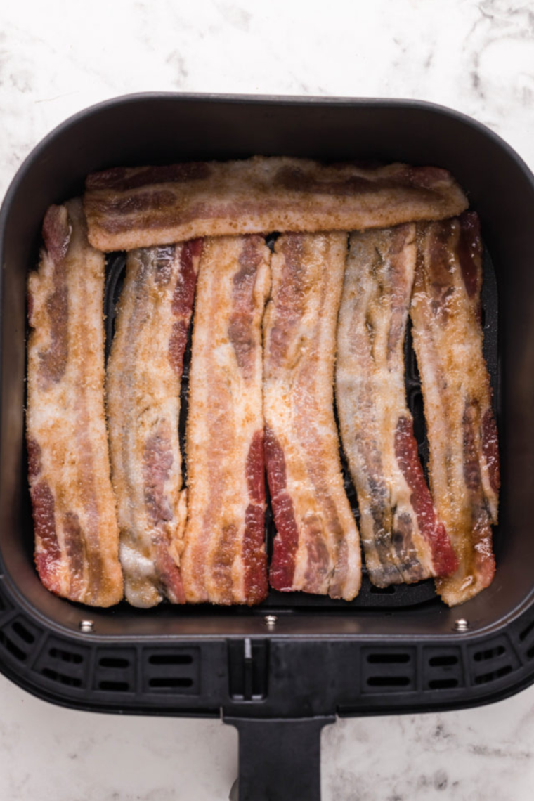 Air fryer with the timer set, cooking diced bacon pieces for homemade bacon bits.