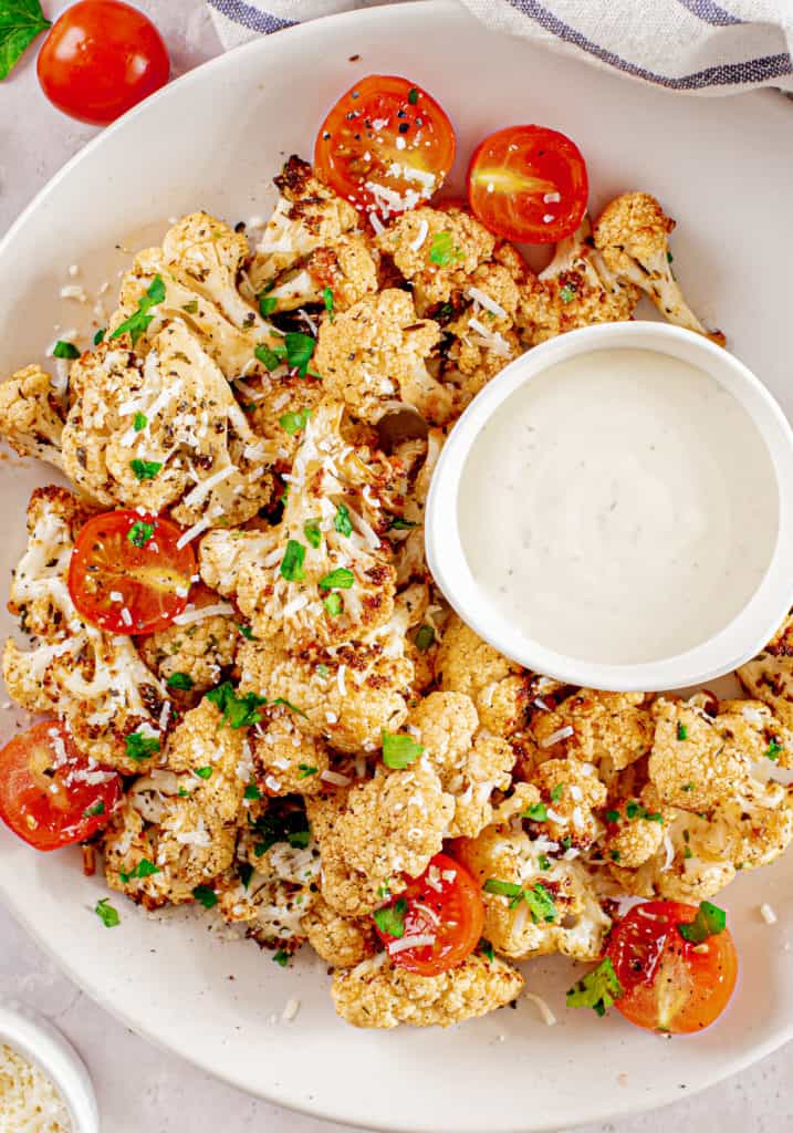 Roasted Cauliflower on Plate with Tomatoes and Dipping Sauce