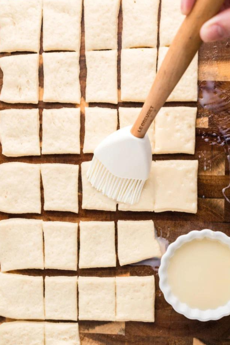 Rolling out pizza dough on a floured surface for making Cinnastix in the Air Fryer.