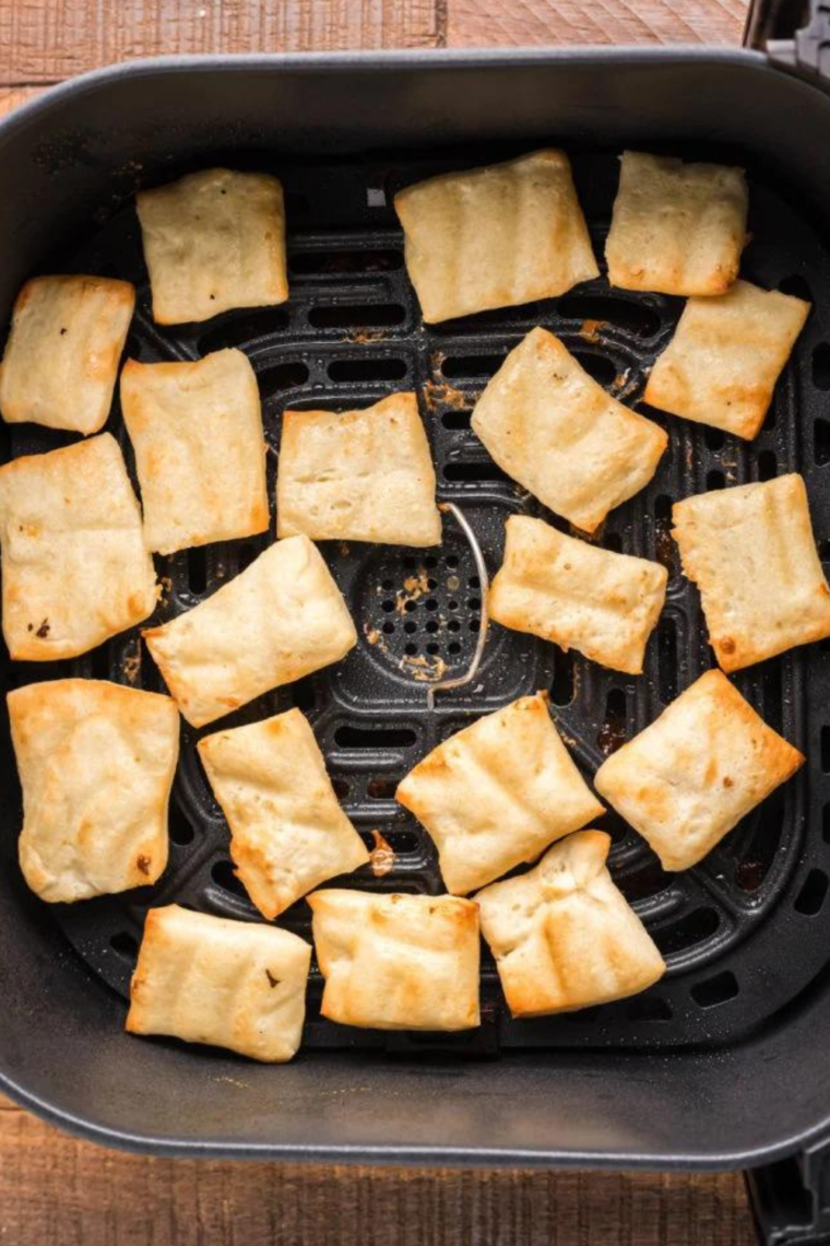 Brushing melted butter onto rolled-out pizza dough for Cinnastix preparation.