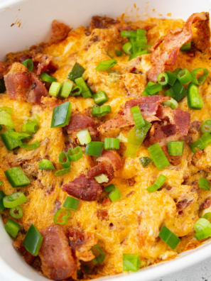 Air fryer jalapeño popper dip in a rustic bowl, creamy and bubbling with melted cheese, topped with sliced jalapeños, crumbled bacon, and scallions