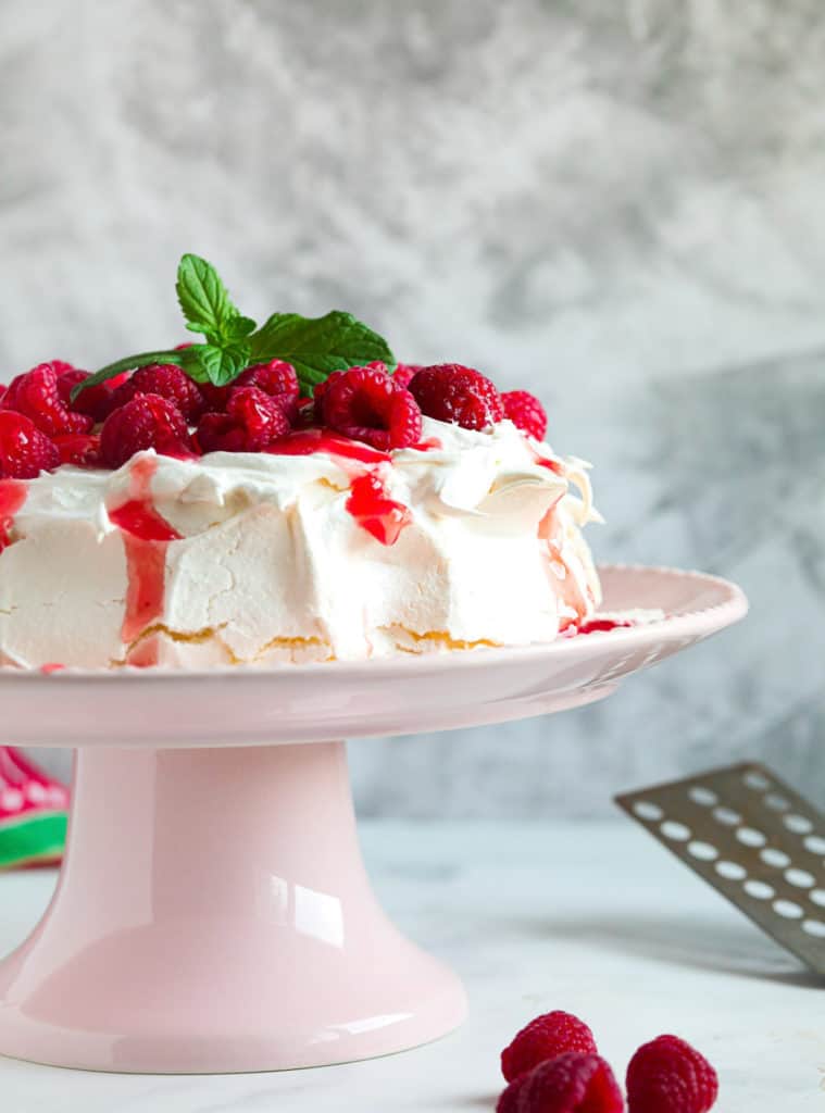 side view: air fryer meringue topped with whipped cream, fresh raspberries, and mint