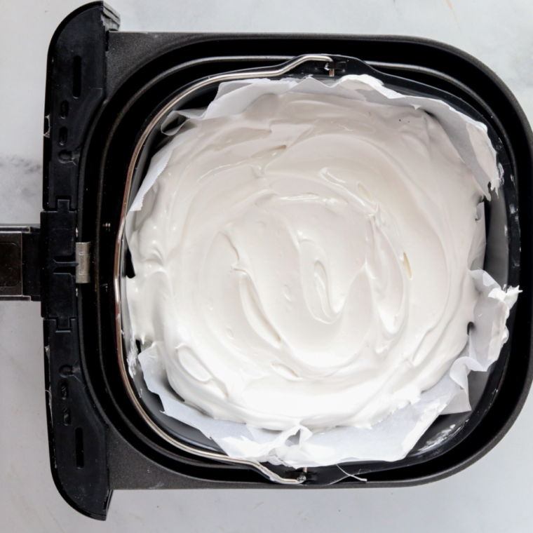 overhead process shot: meringue for raspberry pavlova in the air fryer basket