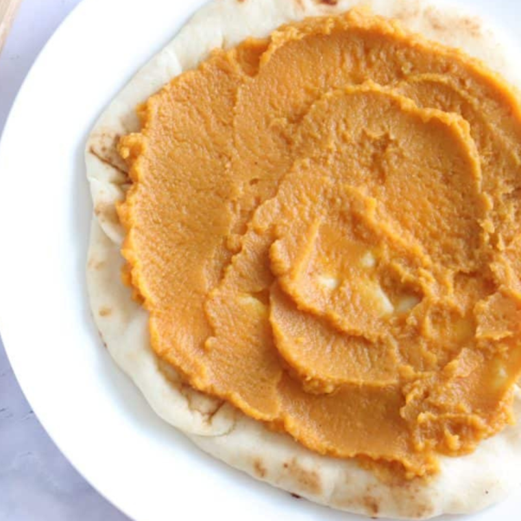 Preheating the air fryer to 400°F and brushing flatbread with olive oil, then spreading pumpkin and sprinkling garlic powder for a savory Air Fryer Savory Pumpkin Ricotta Pizza.