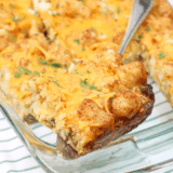 Cheesy air fryer tater tot casserole in a baking dish with golden, crispy tots on top.
