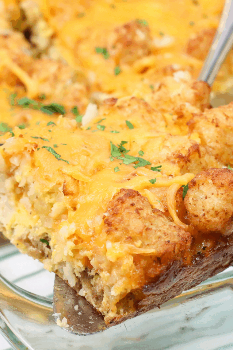 Golden tater tot casserole cooked in the air fryer, topped with melted cheese and crispy tots in a baking dish.