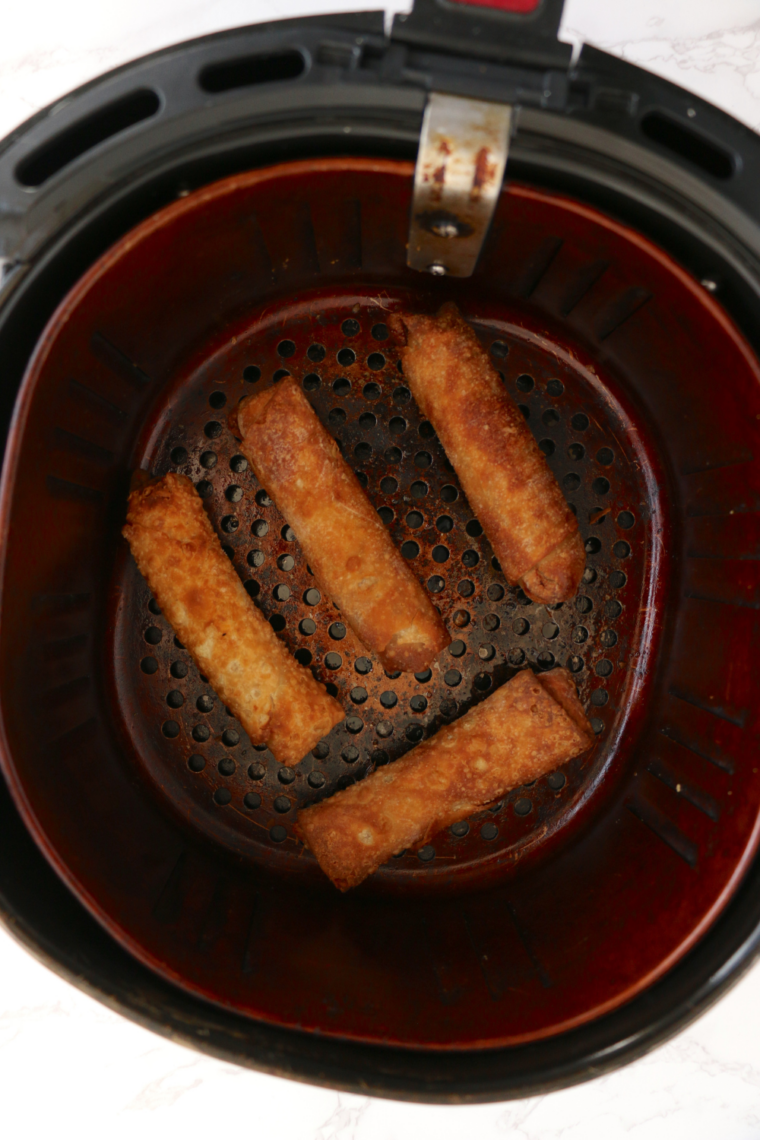 Chung's egg rolls being flipped with tongs halfway through air frying