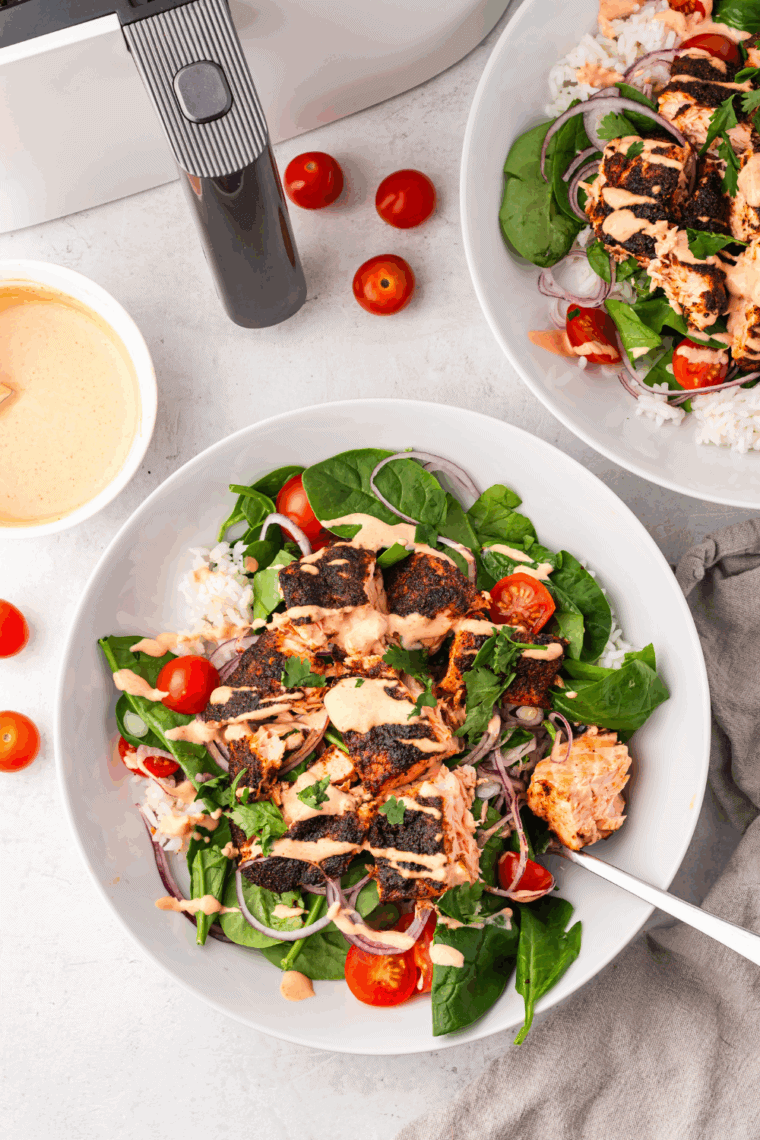 BBQ seasoned salmon fillets cooking in the air fryer until flaky